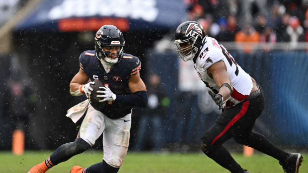 Dec 31, 2023; Chicago, Illinois, USA; Chicago Bears quarterback Justin Fields (1) scrambles away from Atlanta Falcons defensive lineman Calais Campbell (93) in the first half at Soldier Field.